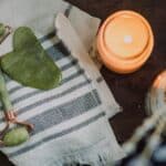 A serene spa setup featuring a jade roller gua sha towel and candle for ultimate relaxation