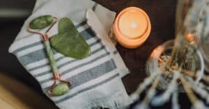 A serene spa setup featuring a jade roller gua sha towel and candle for ultimate relaxation